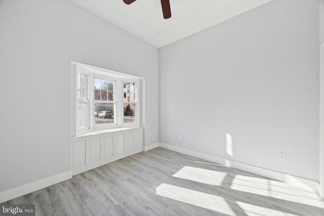 empty room featuring ceiling fan, light hardwood / wood-style flooring, and lofted ceiling