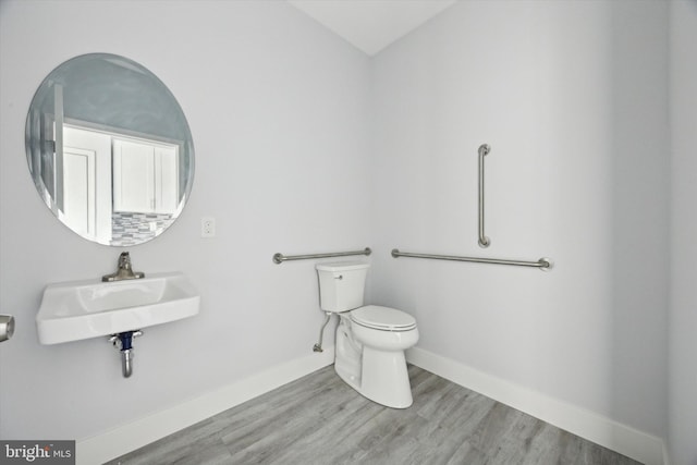 bathroom with wood-type flooring, toilet, and sink