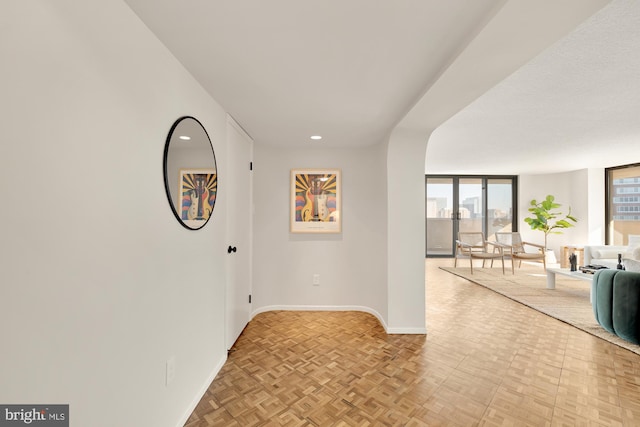 hall featuring a wall of windows and light parquet flooring