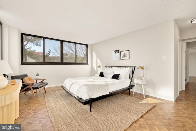 bedroom featuring a textured ceiling and light parquet flooring