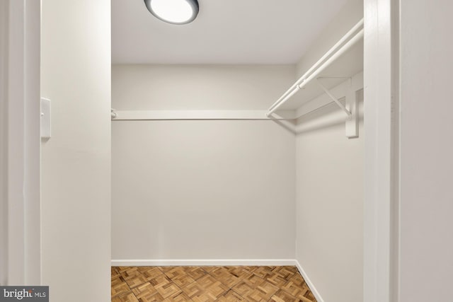 walk in closet featuring parquet floors