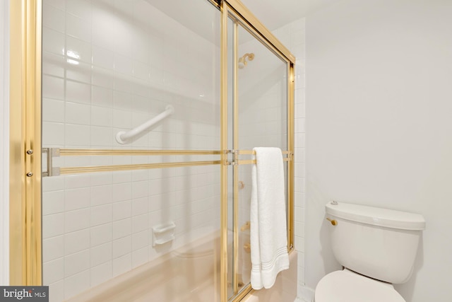 bathroom with a shower with shower door and toilet