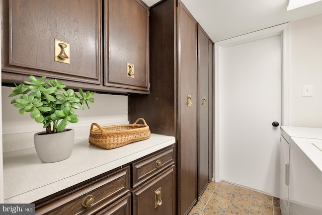 clothes washing area with cabinets and washing machine and clothes dryer