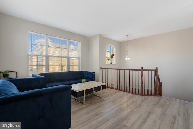 living room with an inviting chandelier and light hardwood / wood-style flooring