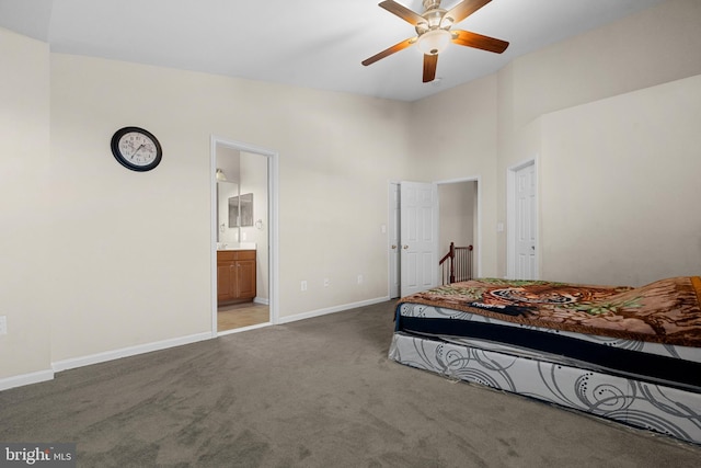 bedroom with ensuite bath, ceiling fan, a high ceiling, and dark colored carpet