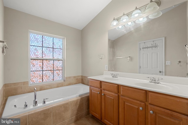 bathroom featuring vanity, tiled bath, and vaulted ceiling