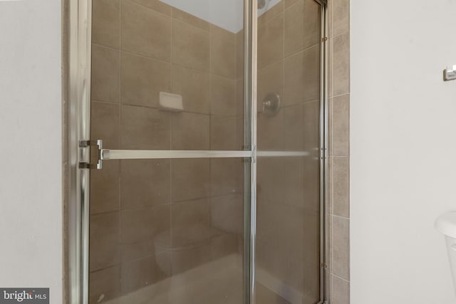 bathroom with an enclosed shower and toilet