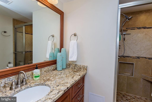 bathroom with vanity and a shower with door