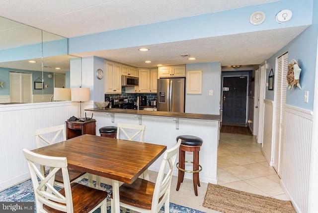 tiled dining space with a textured ceiling