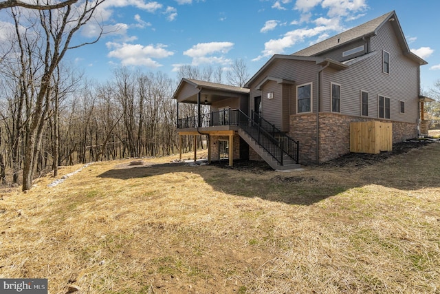 107 S Honeysuckle Dr, Hazle Township, PA 18202 - view of home's exterior with stairs, stone siding, a lawn, and a deck