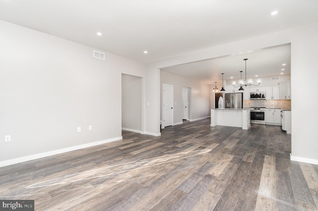 107 S Honeysuckle Dr, Hazle Township, PA 18202 - unfurnished living room featuring a chandelier, recessed lighting, and dark wood-style floors