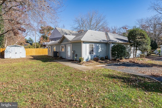 view of side of property featuring a yard and a shed