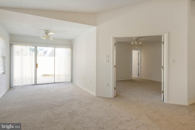 carpeted empty room with ceiling fan and vaulted ceiling