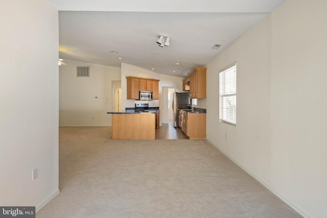 kitchen with light carpet, a kitchen island, and lofted ceiling