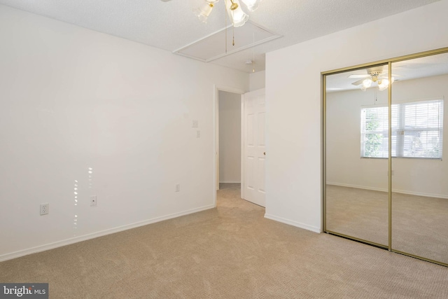 unfurnished bedroom with light carpet and a closet