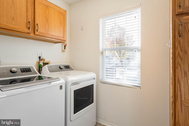 washroom with separate washer and dryer, cabinets, and a healthy amount of sunlight