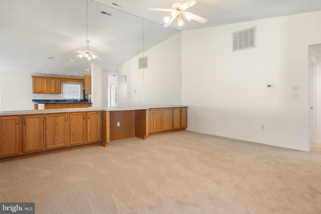 kitchen featuring ceiling fan, lofted ceiling, light carpet, and kitchen peninsula