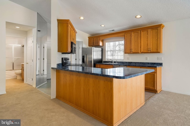 kitchen featuring a textured ceiling, sink, light colored carpet, and stainless steel appliances