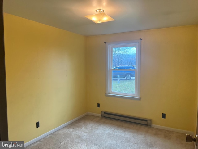 carpeted empty room featuring baseboard heating