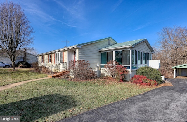 view of front of house with a front lawn and a sunroom