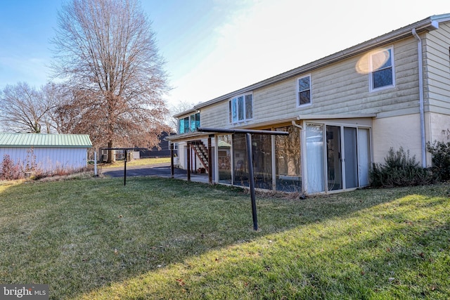 back of property featuring a lawn and a sunroom