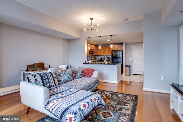 living room featuring light wood-type flooring and an inviting chandelier