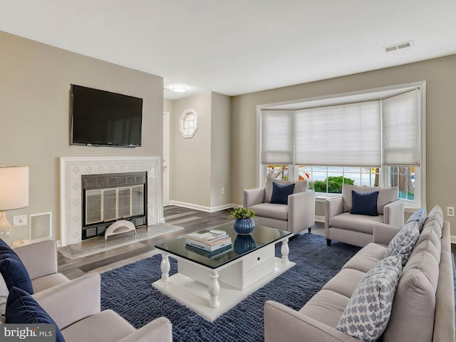 living room with hardwood / wood-style floors and a premium fireplace