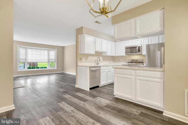 kitchen featuring white cabinetry, sink, dark wood-type flooring, a notable chandelier, and appliances with stainless steel finishes