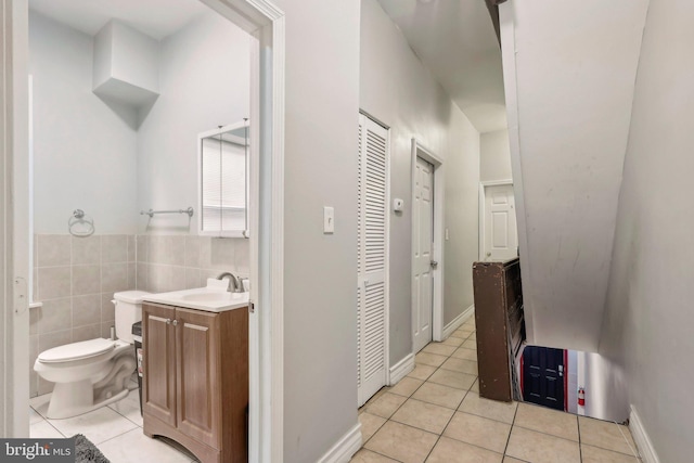 bathroom featuring vanity, tile walls, tile patterned floors, and toilet