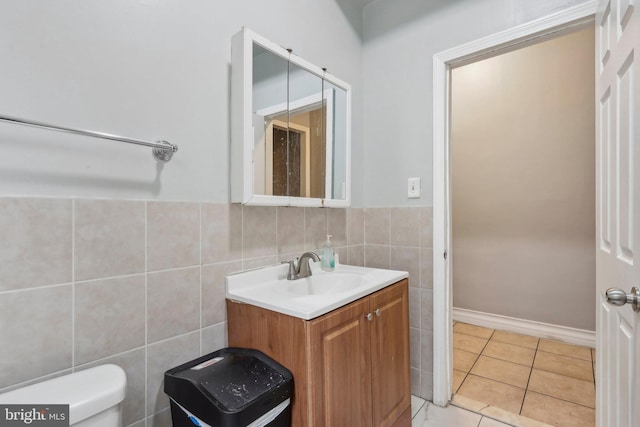 bathroom featuring vanity, tile walls, tile patterned floors, and toilet