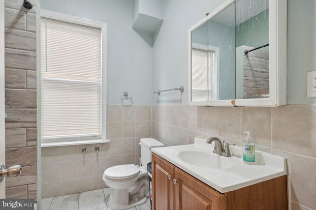 bathroom with vanity, tile walls, and toilet