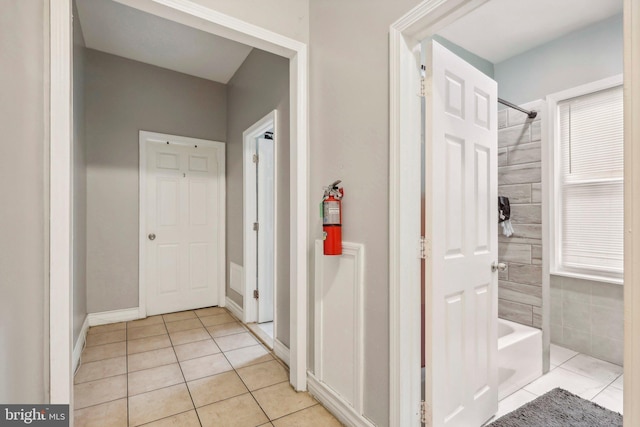 bathroom featuring tile patterned flooring, tiled shower / bath combo, and plenty of natural light