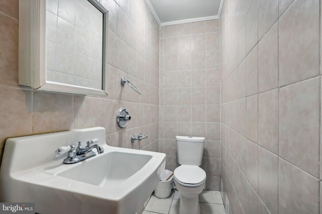 bathroom with sink, crown molding, tile walls, tile patterned floors, and toilet