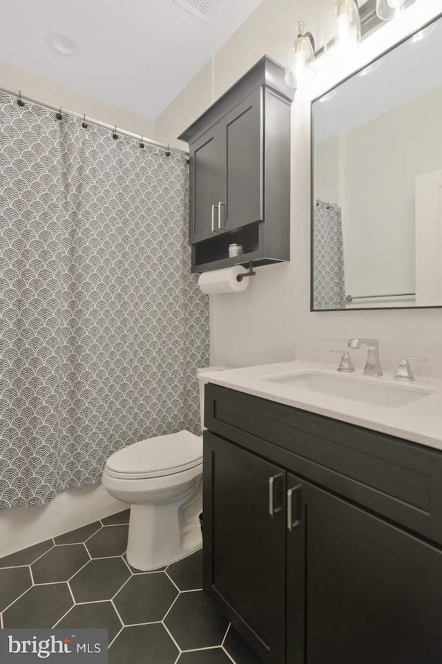 bathroom featuring tile patterned floors, vanity, and toilet