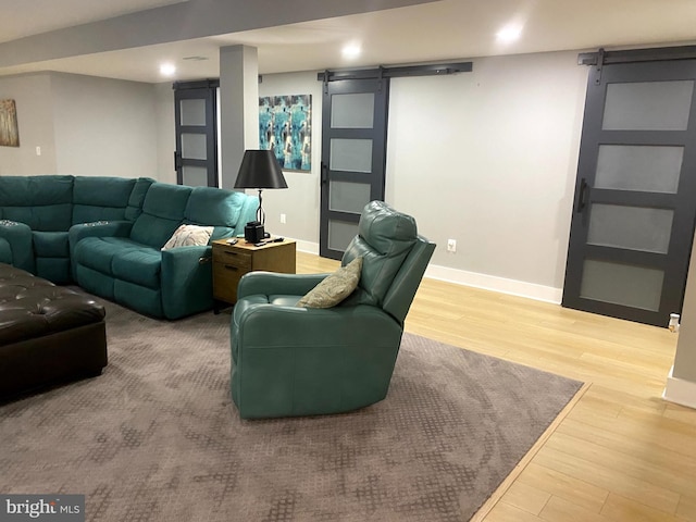 living room with a barn door and hardwood / wood-style flooring