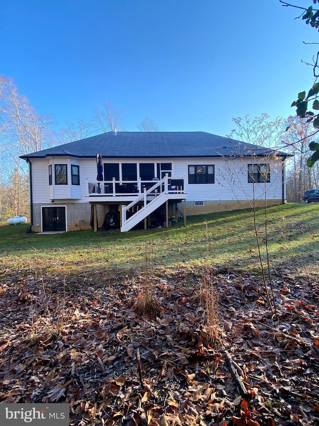 back of property featuring a yard, a sunroom, and a wooden deck