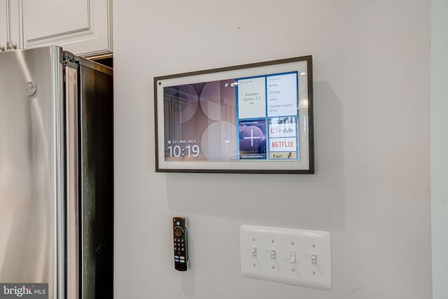 room details with white cabinets and stainless steel refrigerator