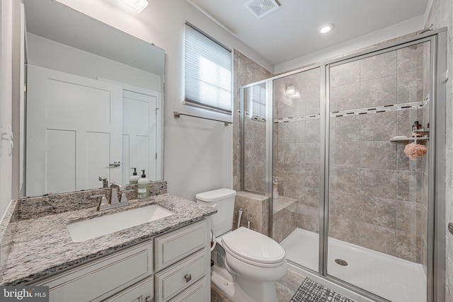 bathroom featuring tile patterned floors, vanity, toilet, and walk in shower