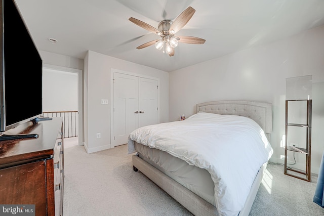 bedroom featuring light carpet, a closet, and ceiling fan