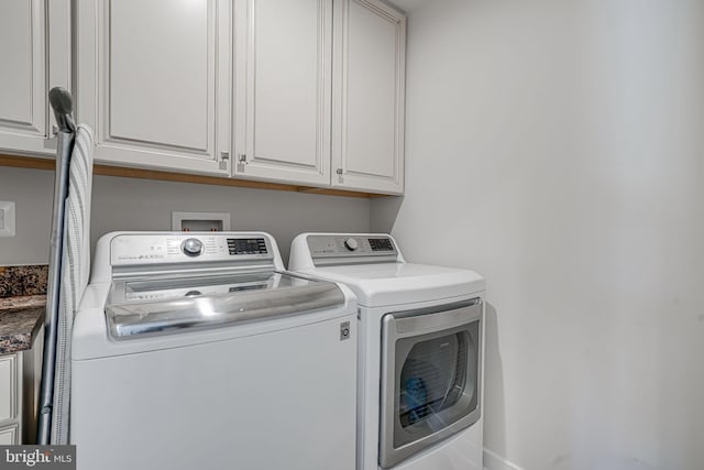 laundry area featuring washing machine and clothes dryer and cabinets