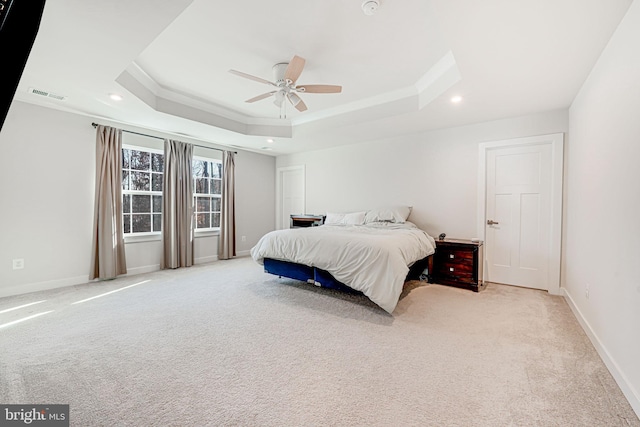 carpeted bedroom featuring a tray ceiling and ceiling fan