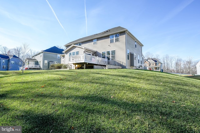 back of house featuring a lawn and a wooden deck