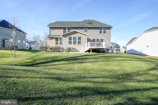 rear view of house with a deck and a yard