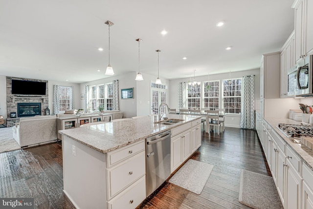 kitchen with a center island with sink, white cabinetry, sink, and appliances with stainless steel finishes