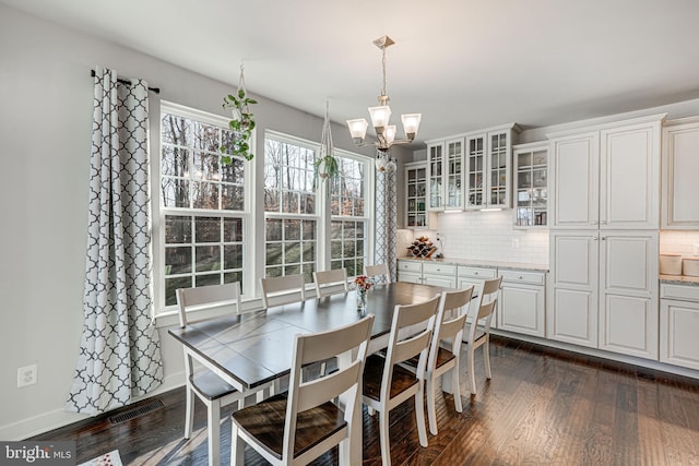 dining space featuring dark hardwood / wood-style floors and an inviting chandelier