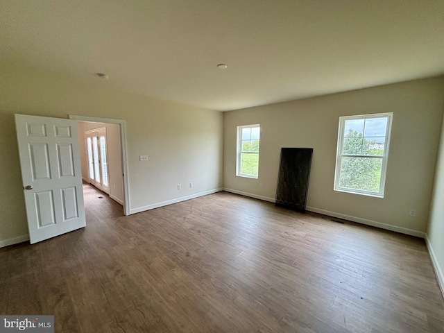 unfurnished living room with light wood-type flooring and plenty of natural light