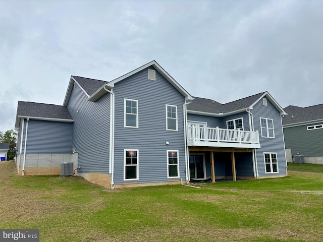 rear view of house featuring a lawn, cooling unit, and a wooden deck