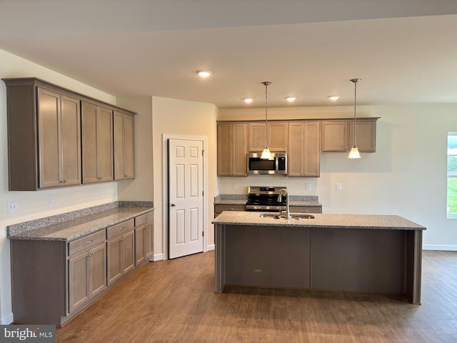 kitchen with decorative light fixtures, stainless steel appliances, stone counters, and dark wood-type flooring