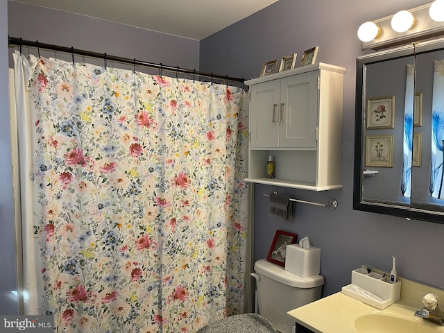 bathroom with vanity, toilet, and curtained shower