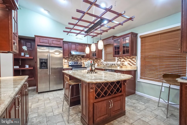 kitchen featuring decorative light fixtures, a center island, decorative backsplash, and stainless steel appliances